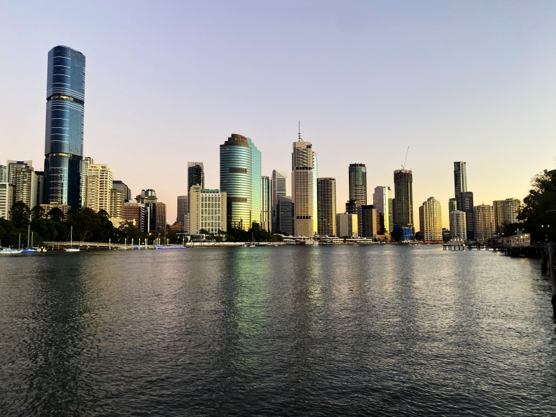 Sunrise reflecting in the windows of buildings over the Bisbane River. Brisbane, Queensland, Australia. 5 August 2021